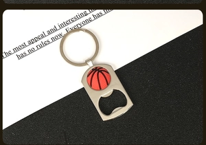 Detail of silver metal basketball keychain bottle opener on textured background