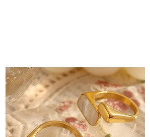 Detailed macro view of a gold-finish ring featuring a rectangular white shell inlay