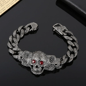 Detail of vintage gunmetal skull bracelet with red zircon eyes and carved links