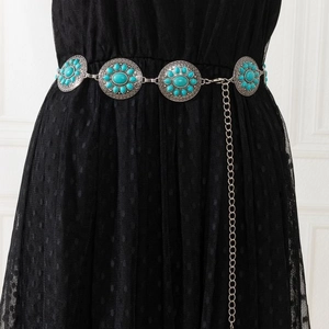 Detail of vintage bohemian silver waist chain with turquoise inlays on black mesh dress