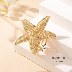 Golden starfish open ring with textured surface on a white background for summer vacation