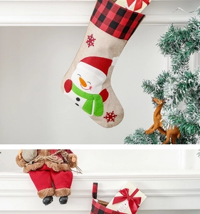Detailed close-up of a buffalo plaid Christmas stocking featuring a snowman embroidery