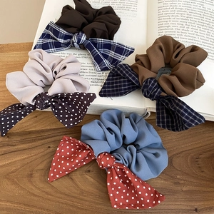 Detail of soft fabric bow scrunchies in polka dot and grid patterns on a vintage book