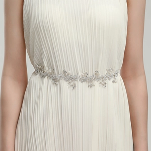 Detail of silver bridal belt with pearls and rhinestones on pleated wedding dress