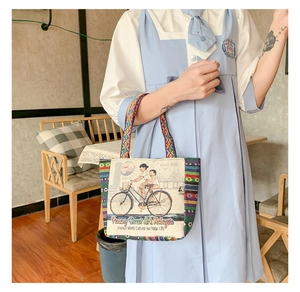 Close-up of ethnic canvas tote with Penang street art print and colorful woven handles