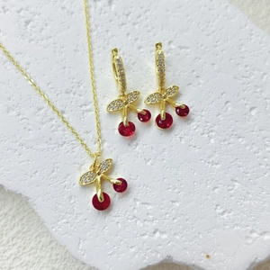 Makro-Detail des Kirschschmuck-Sets mit roten Kristallen und Gold-Finish