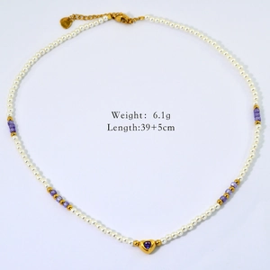 Detail view of gold beaded necklace with purple heart pendant and pearl accents