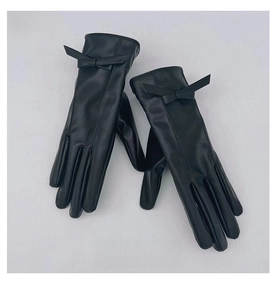 Dettaglio dei guanti invernali da donna in pelle PU nera con eleganti fiocchi sui polsi