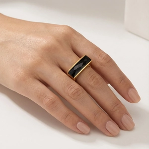 Detailed view of a gold-plated ring featuring a rectangular black faceted gemstone