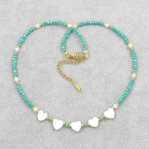 Detail of bohemian style blue crystal beaded bracelet with white heart pendants