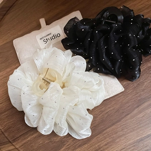 Detail of floral ruffle hair claws in black and cream fabric with sparkly rhinestones