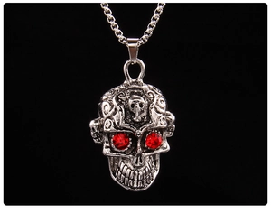 Vue détaillée du pendentif crâne punk avec yeux en pierre rouge et relief argenté