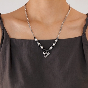 Close-up of heart pendant necklace with pearls and hematite beads on a model's neck