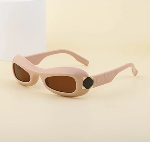 Detail of pink oval sunglasses featuring quilted temples and black octagonal metal accents