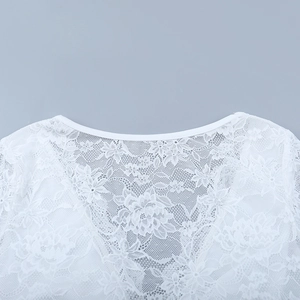 Dettaglio del top in pizzo bianco con ricamo floreale e texture a rete semitrasparente