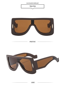 Detail view of tea-colored oversized futuristic visor sunglasses with thick frame