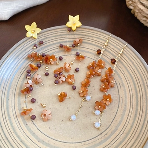 Detailed view of yellow flower resin earrings with pearls on a vintage ceramic plate