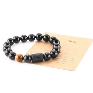 Detail of Taurus zodiac bracelet with 8mm black beads, tiger eye stone and meaning card