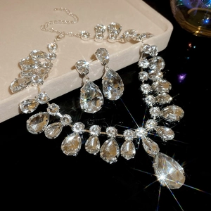 Detailed view of silver water drop necklace and earring set with shimmering crystals