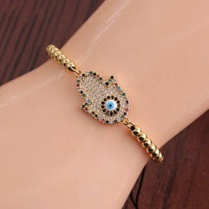 Détail du charm Main de Fatma sur un bracelet perlé doré avec des zircons multicolores