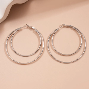 Detail view of double-layered silver geometric metal hoop earrings with leverback closure