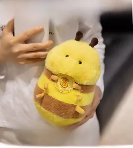 Detail of cute bee duck plush toy with soft yellow fur and golden coin embroidery accessory
