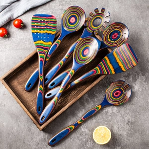 Set premium di 7 utensili da cucina in legno a strisce arcobaleno disposti su un vassoio
