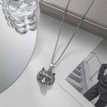 Close-up of silver tiger head pendant necklace on box chain in a lifestyle setting