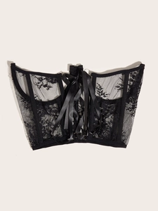 Detailed close-up of a black lace corset featuring intricate patterns and a lace-up back
