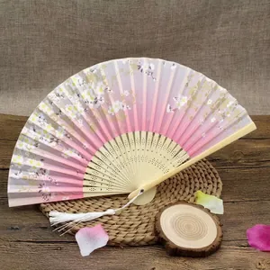 Detail showing Japanese folding fan with pink cherry blossoms and white silk tassel