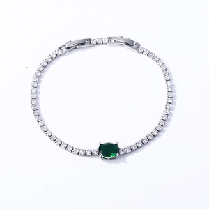Detail of silver tennis bracelet with cubic zirconia and emerald green oval gemstone