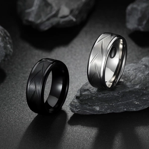 8mm brushed stainless steel rings in black and silver on dark stone background