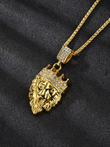Detailed view of golden lion head pendant with crystal-encrusted crown on dark leather