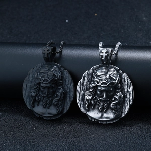 Detailed view of silver and black St. Benedict pendant necklaces with vintage relief