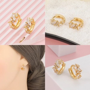 Primer plano de pendientes de oro de 18K con circonitas de pera usados por modelo
