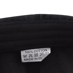 Detailed macro view of the 100% cotton washing label inside the black baseball cap