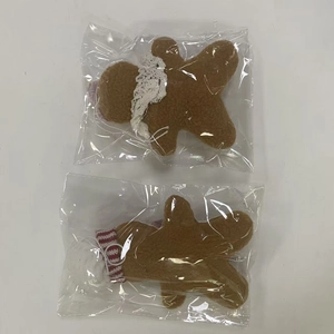 Detail of plush gingerbread man Christmas tree ornaments with lace and bow tie details
