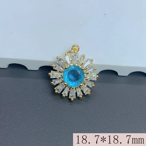 Macro detail of gold flower pendant with blue zircon center and rectangular petals