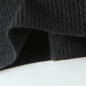Close-up of dark grey knitted ribbed fabric texture on casual two-piece sweater set