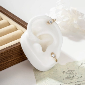 French vintage gold earrings with zircons shown on a white ear model for a classy look