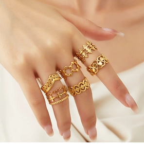 Detail of six gold-plated 18K rings with crown and heart patterns on female hand