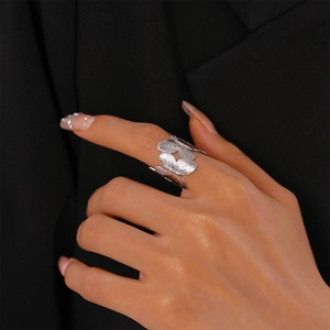 Detailed view of silver butterfly open ring with textured wings worn on hand