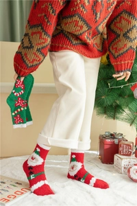Détail de chaussettes de Noël épaisses en polaire corail avec motifs Père Noël