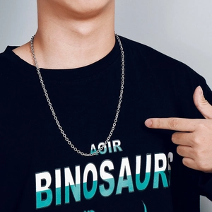 Close-up of a silver stainless steel O-chain necklace worn by a model on a black shirt