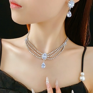 Close-up of elegant silver tiered necklace and drop earrings with sparkling crystals