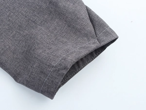 Detail shot of grey blazer fabric showing fine linen texture and double stitching