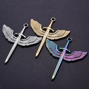Detailed view of three stainless steel sword wing pendants in silver, gold and rainbow finish
