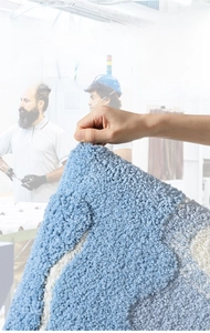 Close-up of durable blue and white fiber weave bath mat showing non-shedding texture