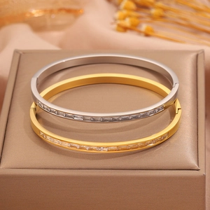 Detail of gold and silver titanium steel bracelets with rectangular pave-set crystals