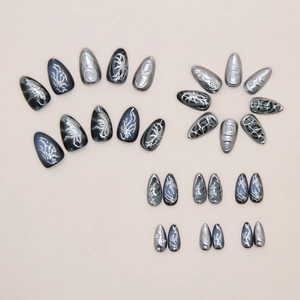 Detailed view of silver metallic almond press-on nails with punk 3D branch textures
